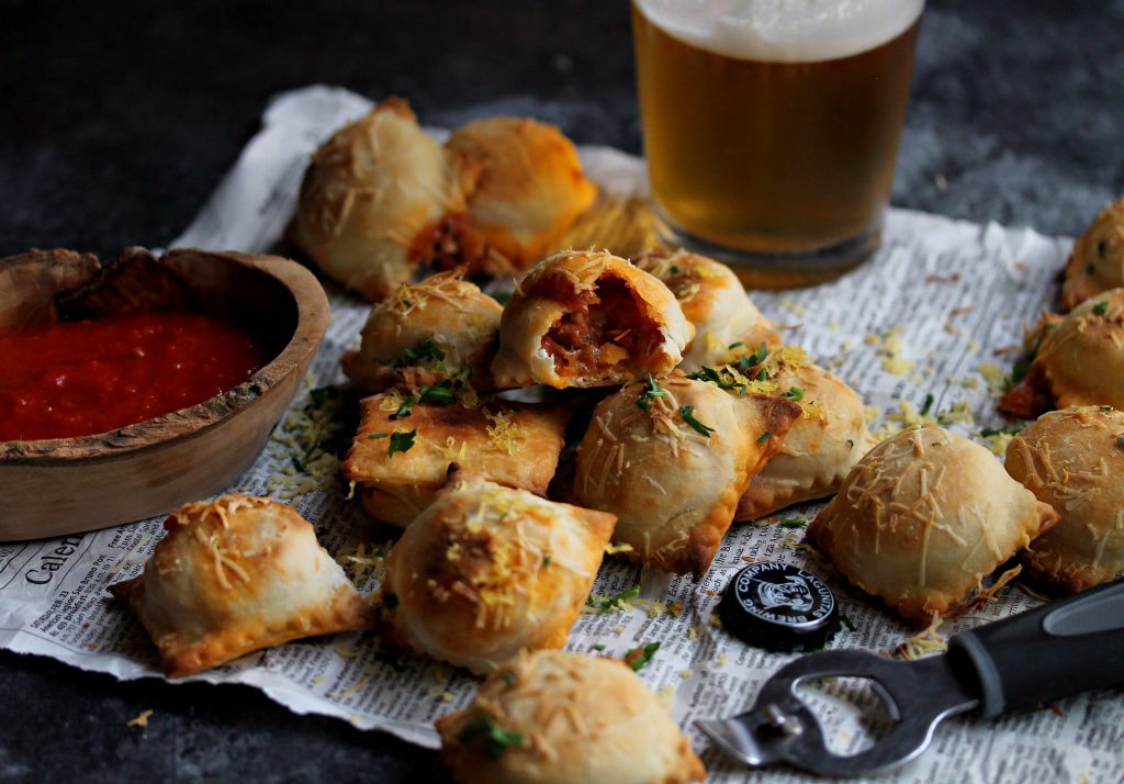 Vegan pizza rolls served on a plate with a side of marinara sauce for dipping.