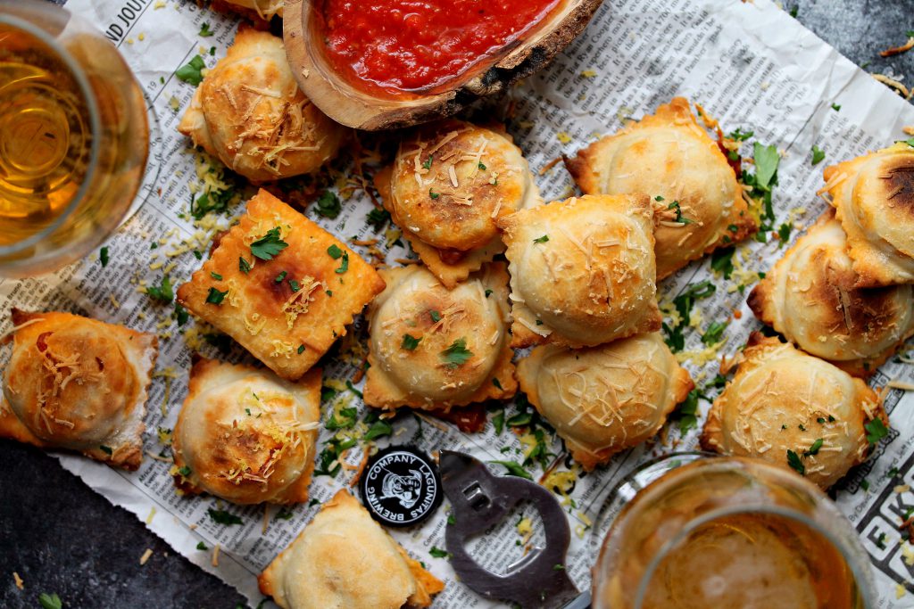 Crispy, golden-brown vegan pizza rolls fresh out of the oven, garnished with fresh parsley and vegan parmesan.