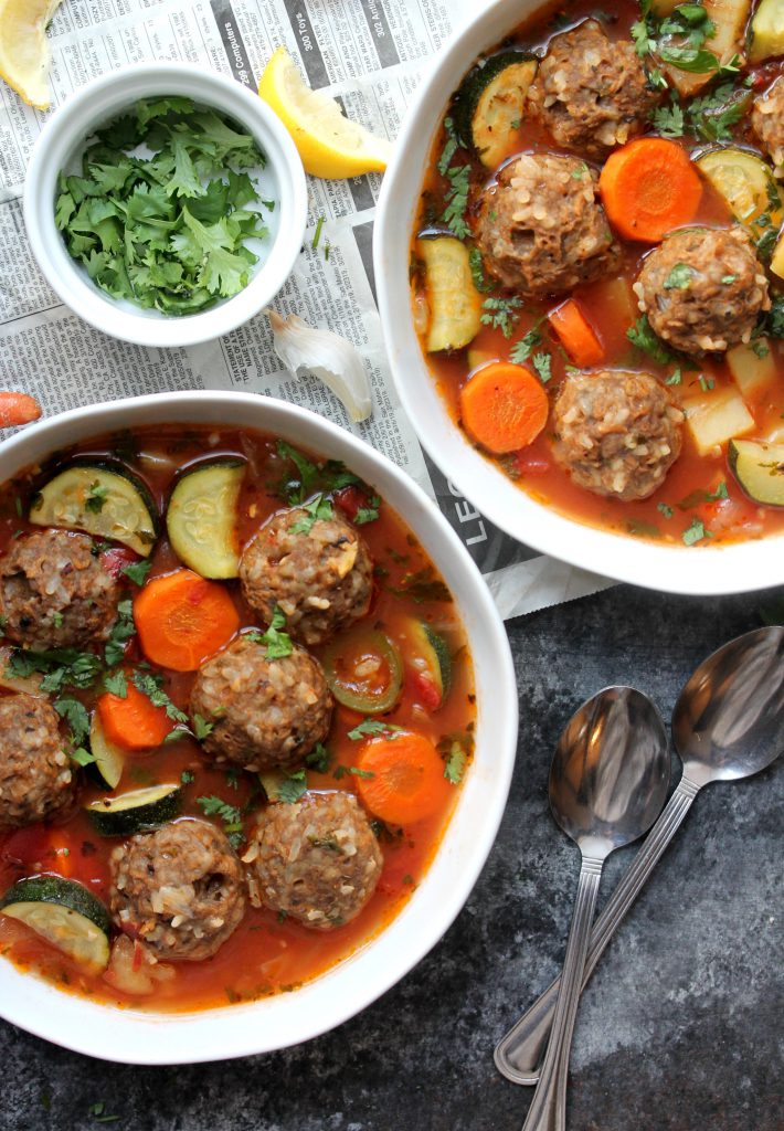 A steaming bowl of vegan Sopa de Albóndigas (Mexican Meatball Soup) with fresh cilantro and jalapeño slices.