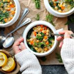 A bowl of Lemon Dill Chickpea Orzo Soup garnished with fresh dill and a lemon wedge, ready to be enjoyed.