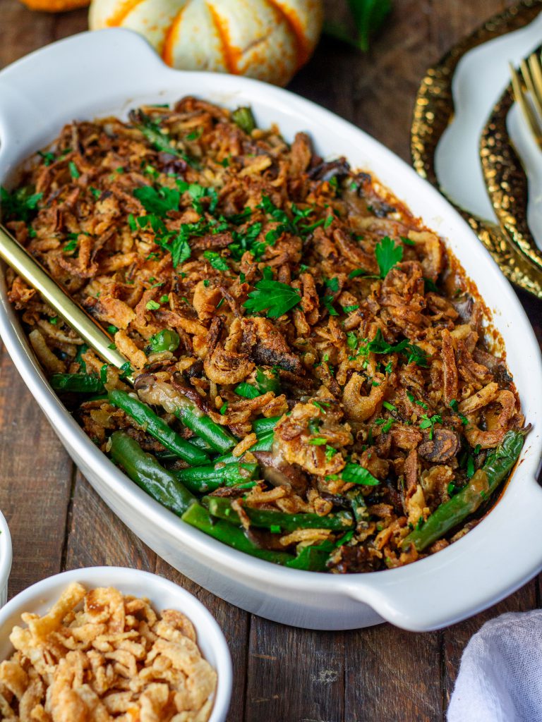 Golden baked Vegan Green Bean Casserole topped with crispy onion strings and fresh parsley.