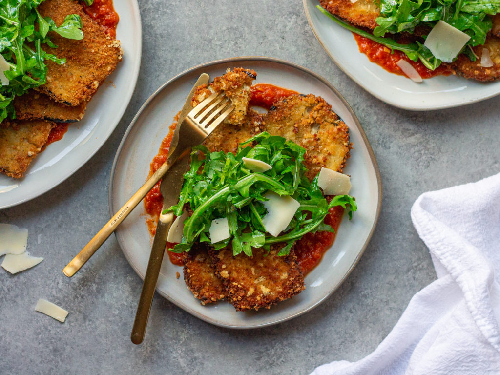 Crispy Parmesan Eggplant with marinara sauce, crispy eggplant, and fresh arugula.