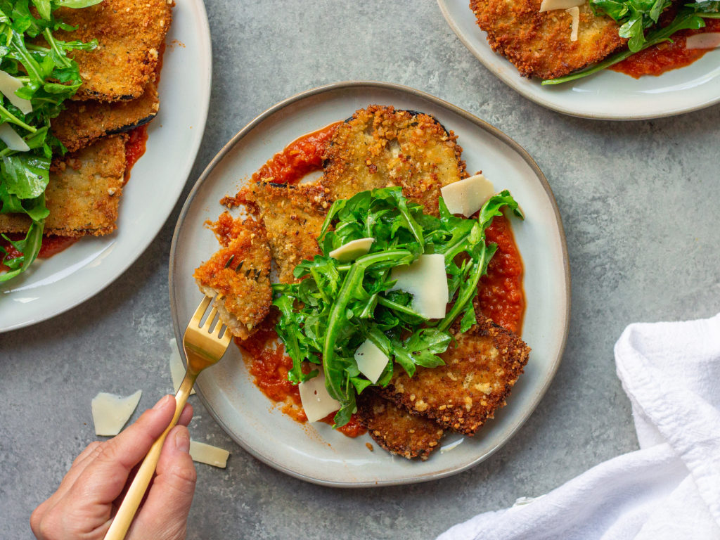 Crispy Parmesan Eggplant with with marinara sauce, crispy eggplant, and fresh arugula.