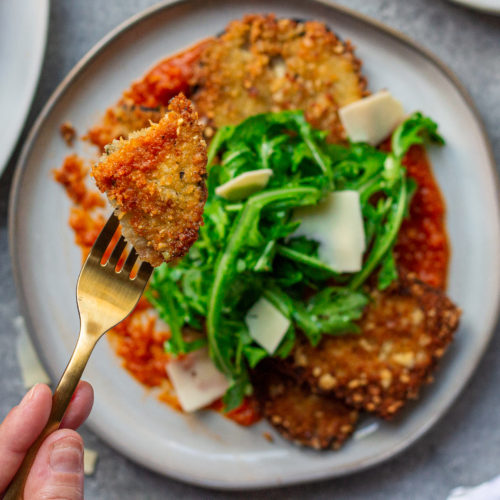 Crispy Parmesan Eggplant with with marinara sauce, crispy eggplant, and fresh arugula.