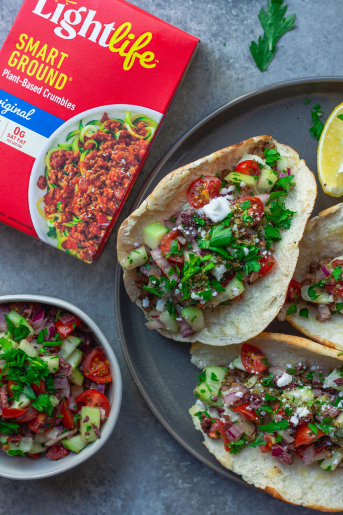 A beautifully presented meal with a plate of Vegan Mediterranean Tacos, a side of salad, and a drizzle of tzatziki sauce, ready to be enjoyed.