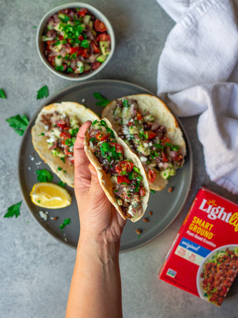 A beautifully presented meal with a plate of Vegan Mediterranean Tacos, a side of salad, and a drizzle of tzatziki sauce, ready to be enjoyed.