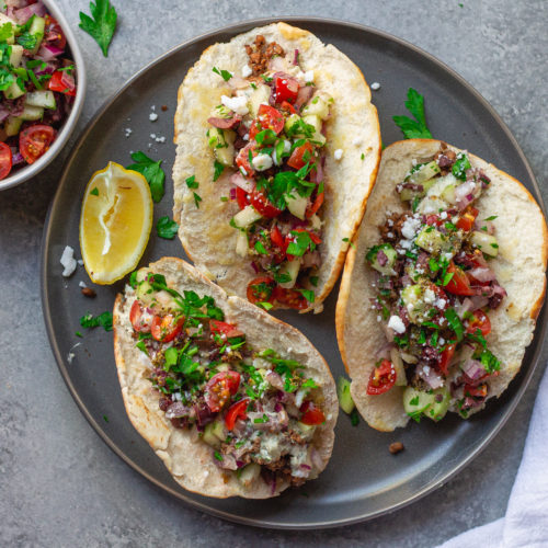 A close-up of a Vegan Mediterranean-Inspired Taco with pita bread shell, showcasing the colorful Mediterranean salad and Lightlife Smart Ground filling.