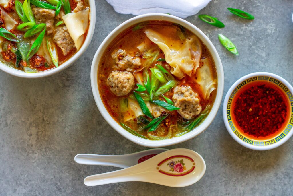 Close-up of vegan wonton meatballs floating in the flavorful broth of the deconstructed soup.