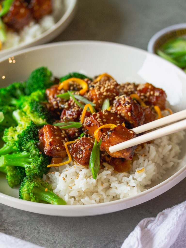 A stunning platter showcasing the finished dish – orange glazed tofu with vibrant garnishes and side dishes.