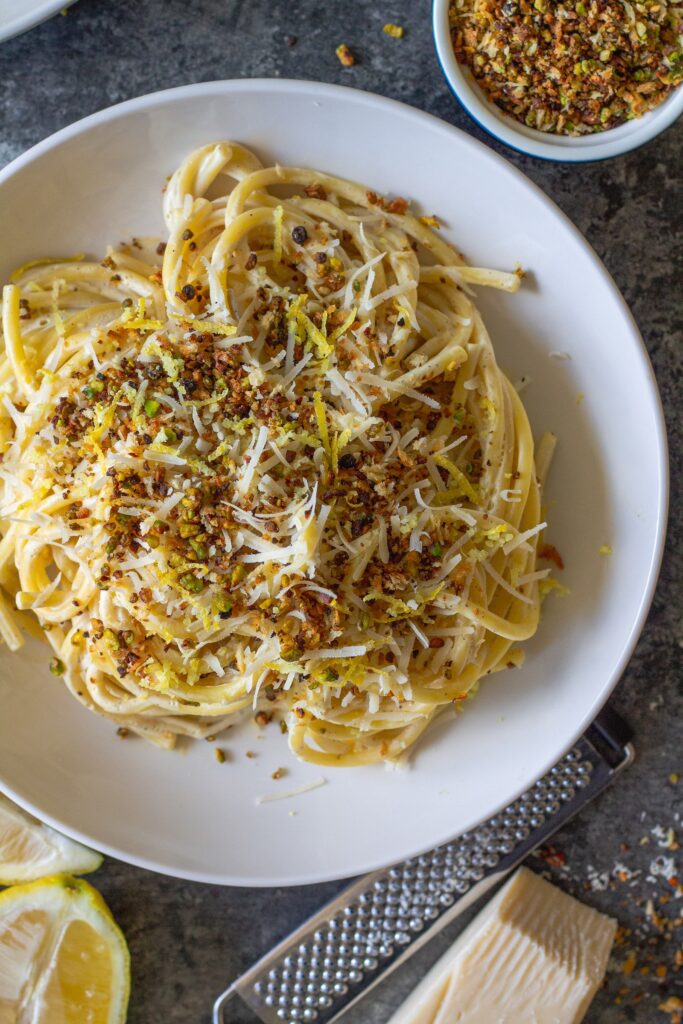 Cooked pasta coated in creamy lemon sauce with homemade garlicky pistachio breadcrumbs.