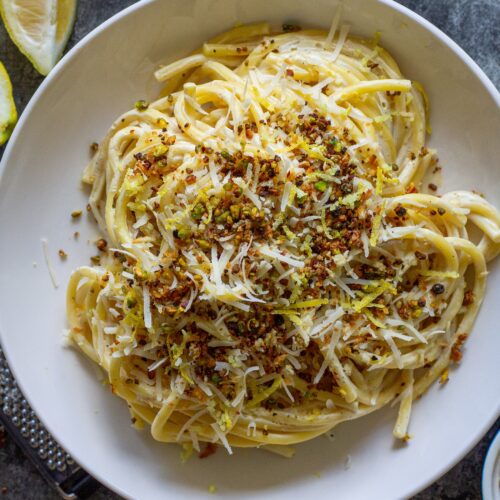Cooked pasta coated in creamy lemon sauce with homemade garlicky pistachio breadcrumbs.