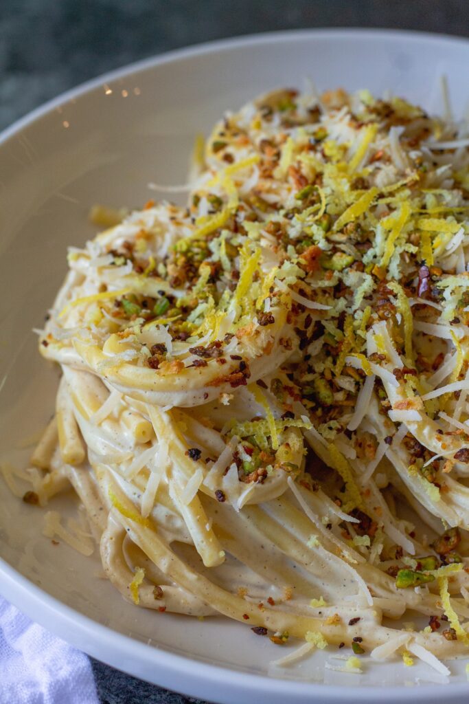 Cooked pasta coated in creamy lemon sauce with garlicky pistachio breadcrumbs.