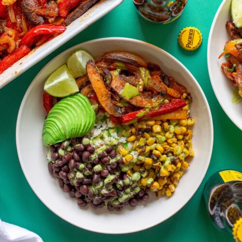 Vegan Mushroom Fajita Bowl with cilantro lime rice, roasted portobello mushrooms, black beans, corn, avocado, and drizzled with cilantro lime crema.