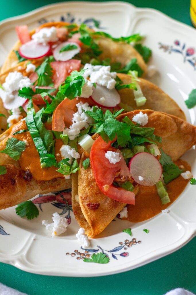 Homemade crispy potato tacos served with garlic tomato sauce and assorted garnishes