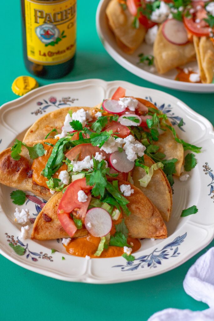 Homemade crispy potato tacos served with garlic tomato sauce and assorted garnishes