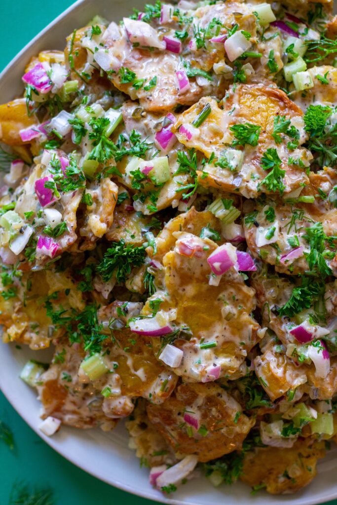 Vegan Old Bay Smashed Potato Salad served in a large bowl, garnished with fresh dill, ready to be served