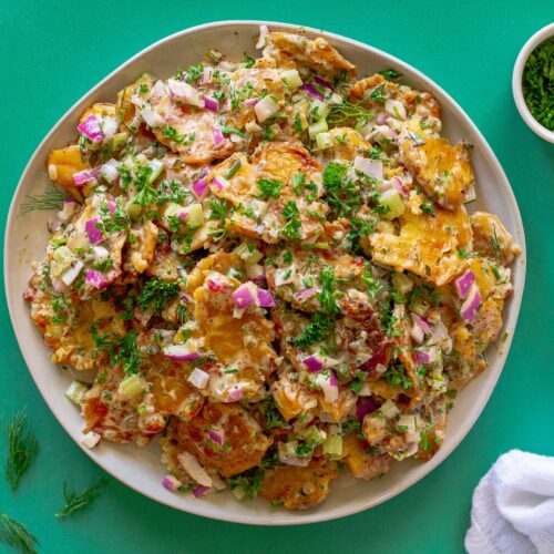 Vegan Old Bay Smashed Potato Salad served in a large bowl, garnished with fresh dill, ready to be served