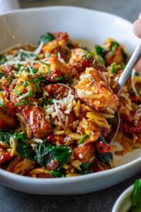 Marry Me Tofu and Orzo garnished with fresh basil and vegan parmesan.