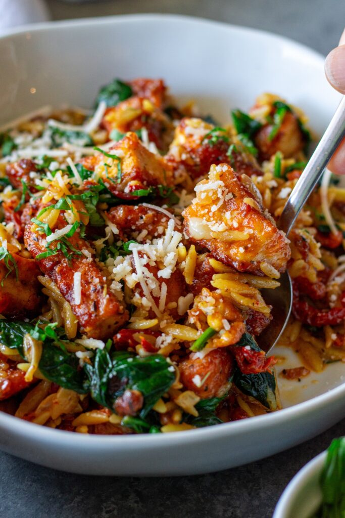 Marry Me Tofu and Orzo garnished with fresh basil and vegan parmesan.
