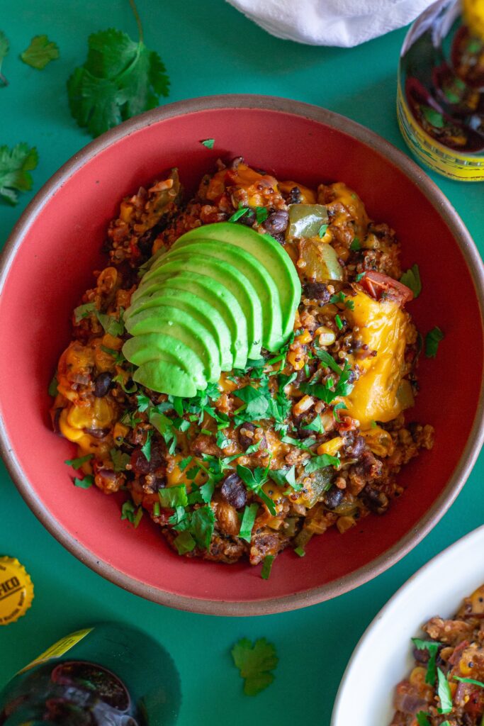 A vibrant bowl filled with Southwest Chick’n and Rice, topped with melted vegan cheese and fresh cilantro.
