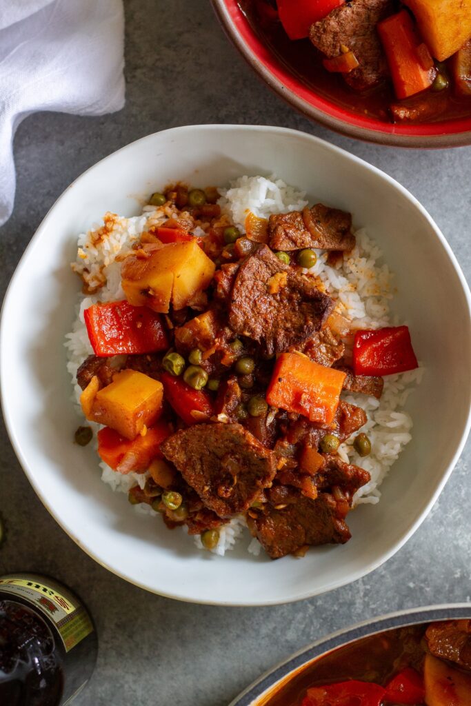 A bowl of vegan Mechado served over fluffy white rice.