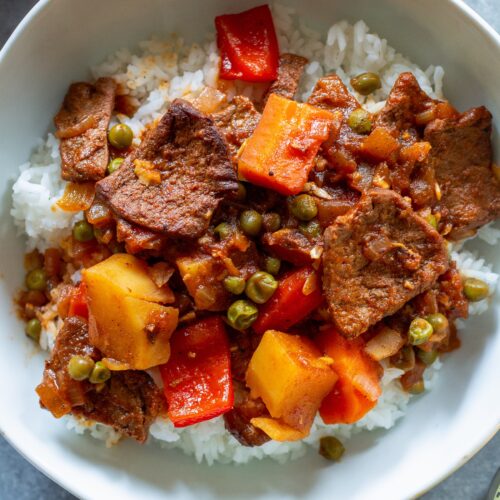 A bowl of vegan Mechado served over fluffy white rice.