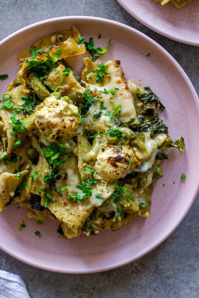 Finished lasagna topped with melty mozzarella, dollops of tofu ricotta, and fresh parsley
