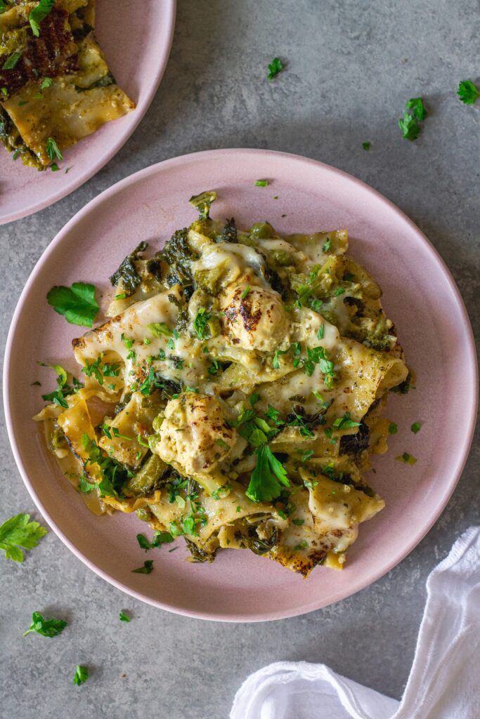 Finished lasagna topped with melty mozzarella, dollops of tofu ricotta, and fresh parsley