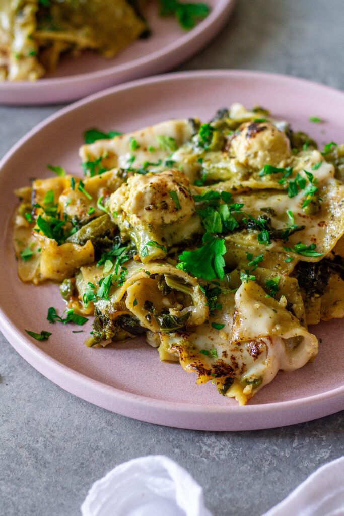 Finished lasagna topped with melty mozzarella, dollops of tofu ricotta, and fresh parsley
