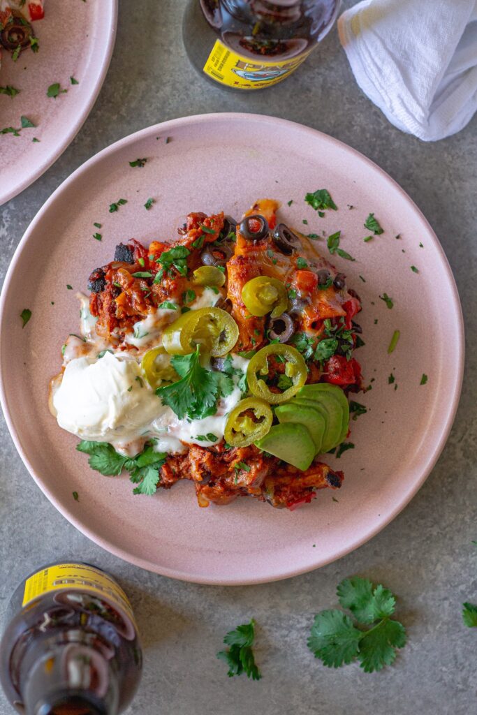 Overhead shot of the finished One Pan Chick’n Enchilada Skillet garnished with avocado, cilantro, and jalapeños