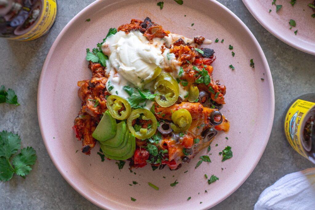 Overhead shot of the finished One Pan Chick’n Enchilada Skillet garnished with avocado, cilantro, and jalapeños