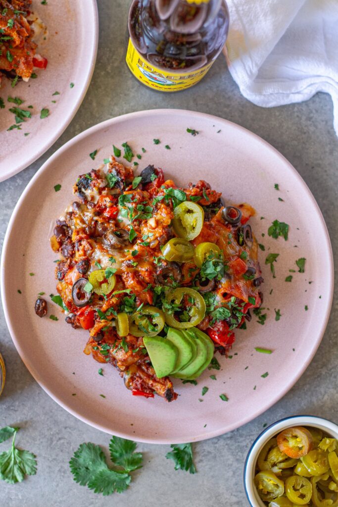Overhead shot of the finished One Pan Chick’n Enchilada Skillet garnished with avocado, cilantro, and jalapeños