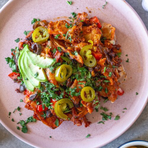 shot of the finished One Pan Chick’n Enchilada Skillet garnished with avocado, cilantro, and jalapeños