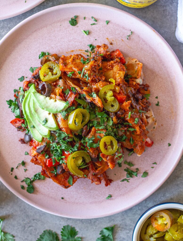 shot of the finished One Pan Chick’n Enchilada Skillet garnished with avocado, cilantro, and jalapeños
