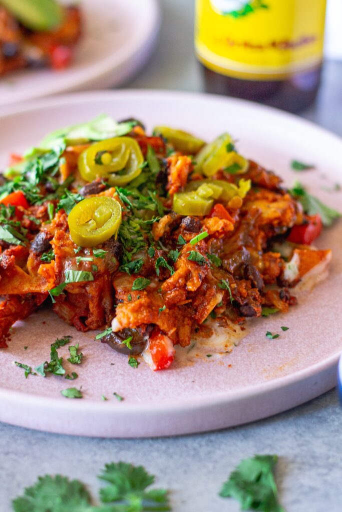 shot of the finished One Pan Chick’n Enchilada Skillet garnished with avocado, cilantro, and jalapeños