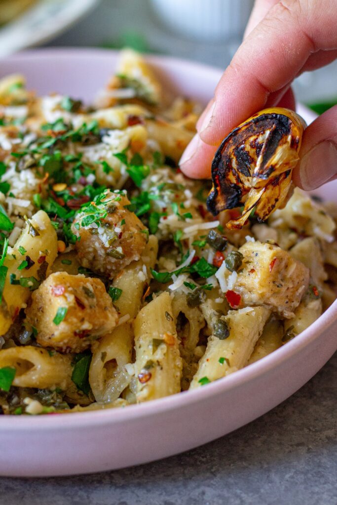 A fork scooping up a bite of tofu and pasta with melted cheese strings.