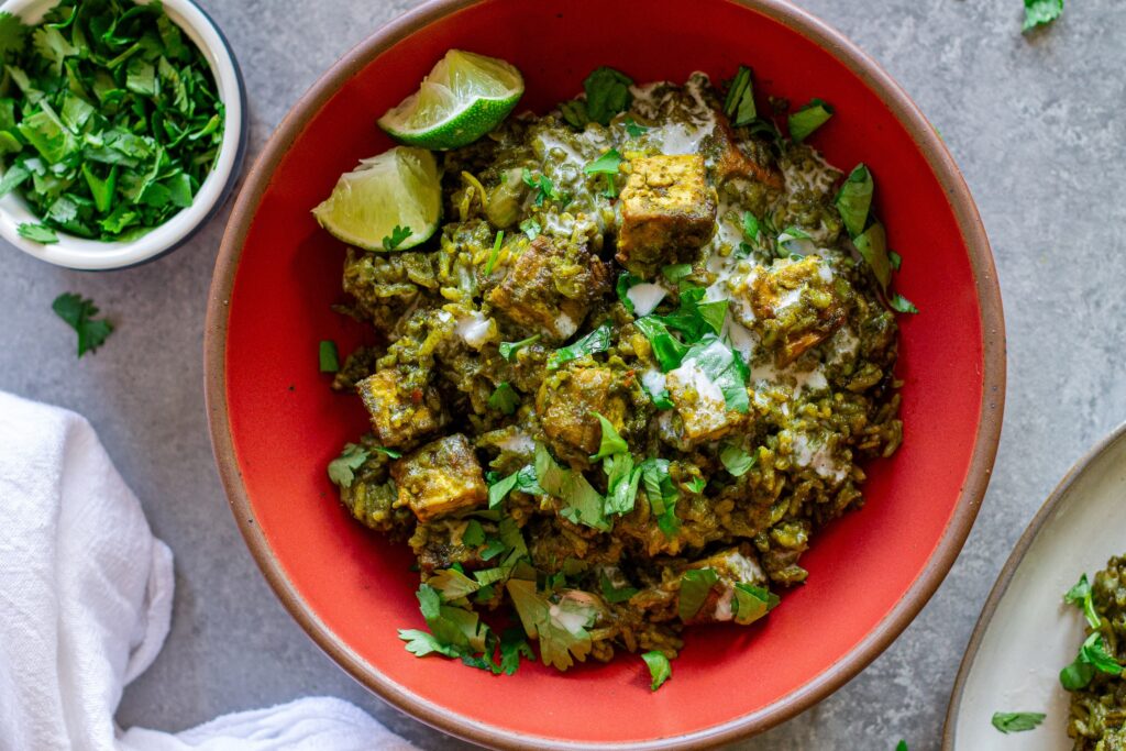 One-pan coconut cilantro rice and tofu garnished with sour cream, lime and cilantro.