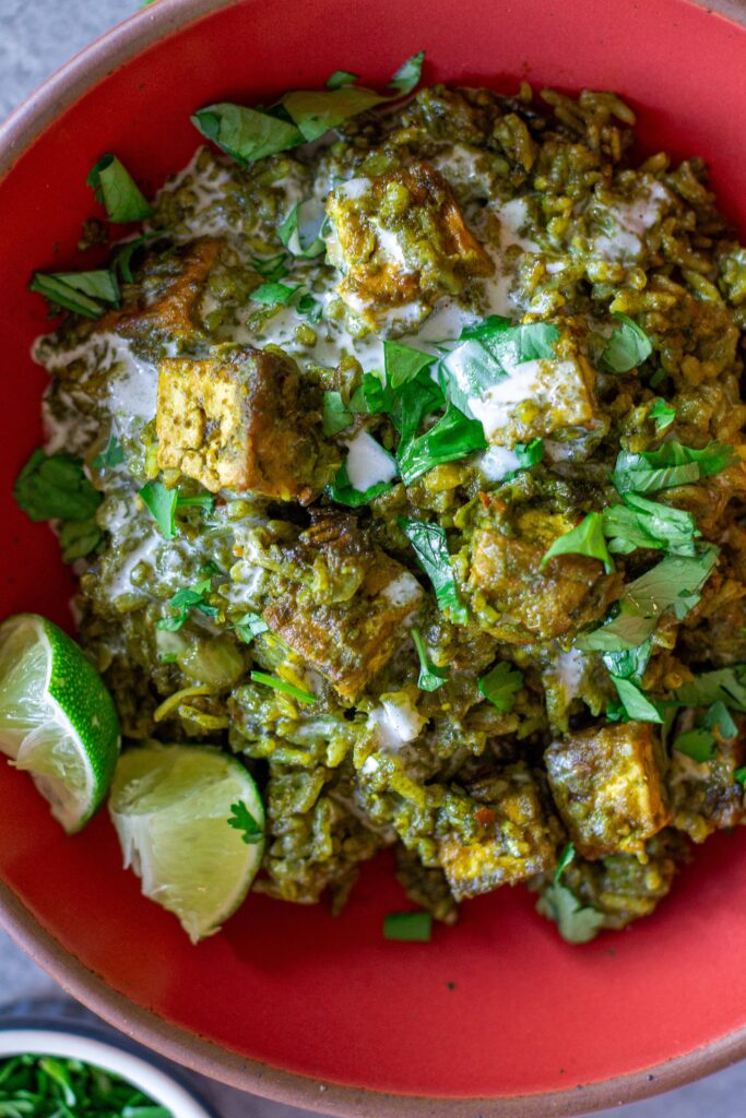 One-pan coconut cilantro rice and tofu garnished with sour cream, lime and cilantro.