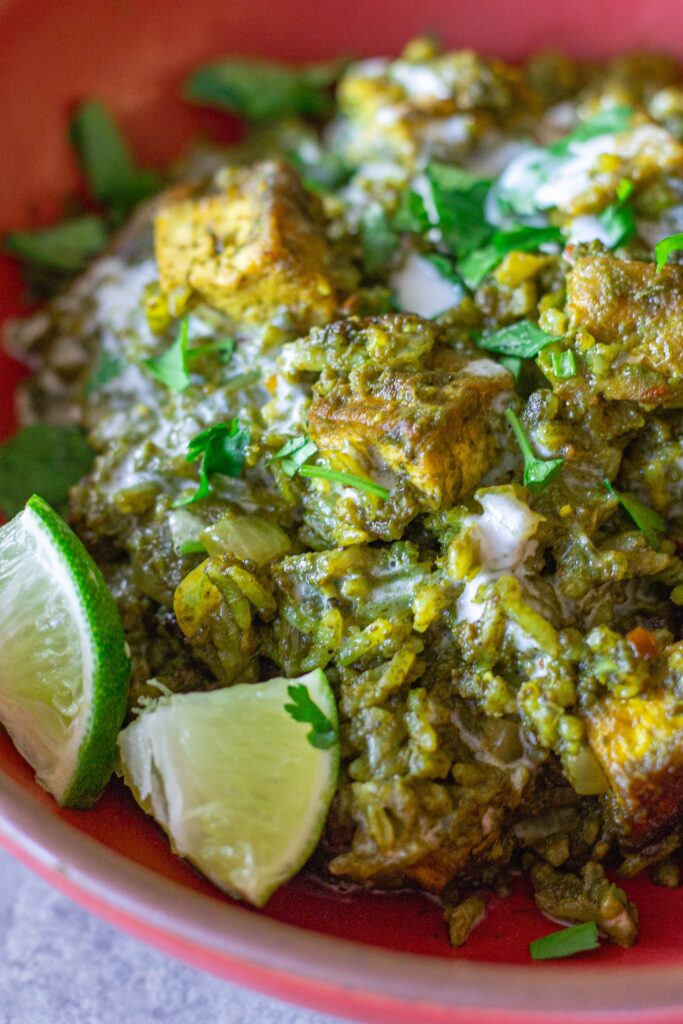One-pan coconut cilantro rice and tofu garnished with sour cream, lime and cilantro.