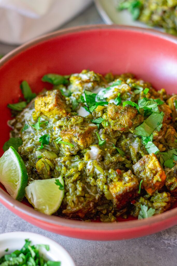One-pan coconut cilantro rice and tofu garnished with sour cream, lime and cilantro.