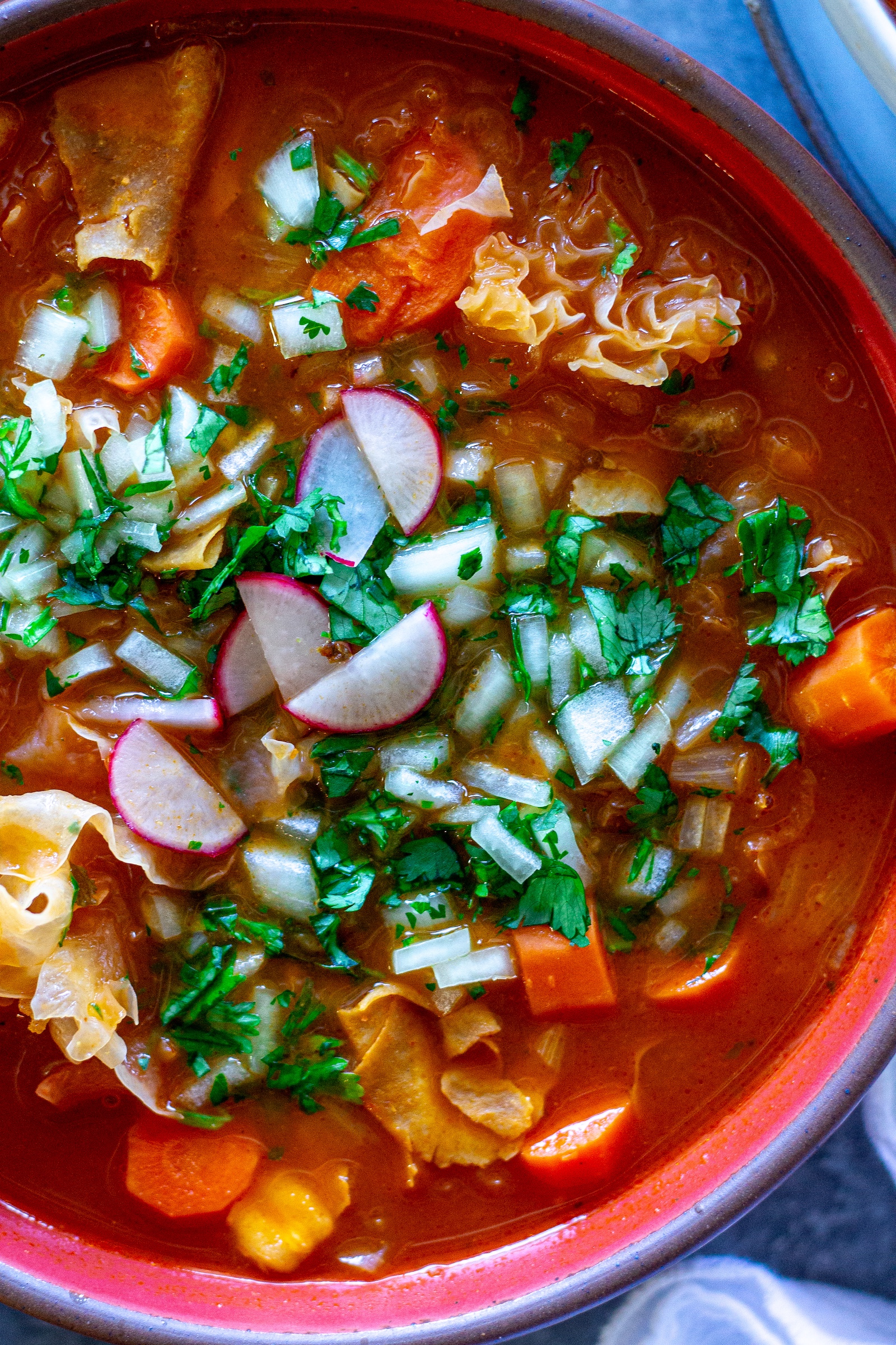Bowl of vegan menudo with snow mushrooms, hominy, and red Chile broth.