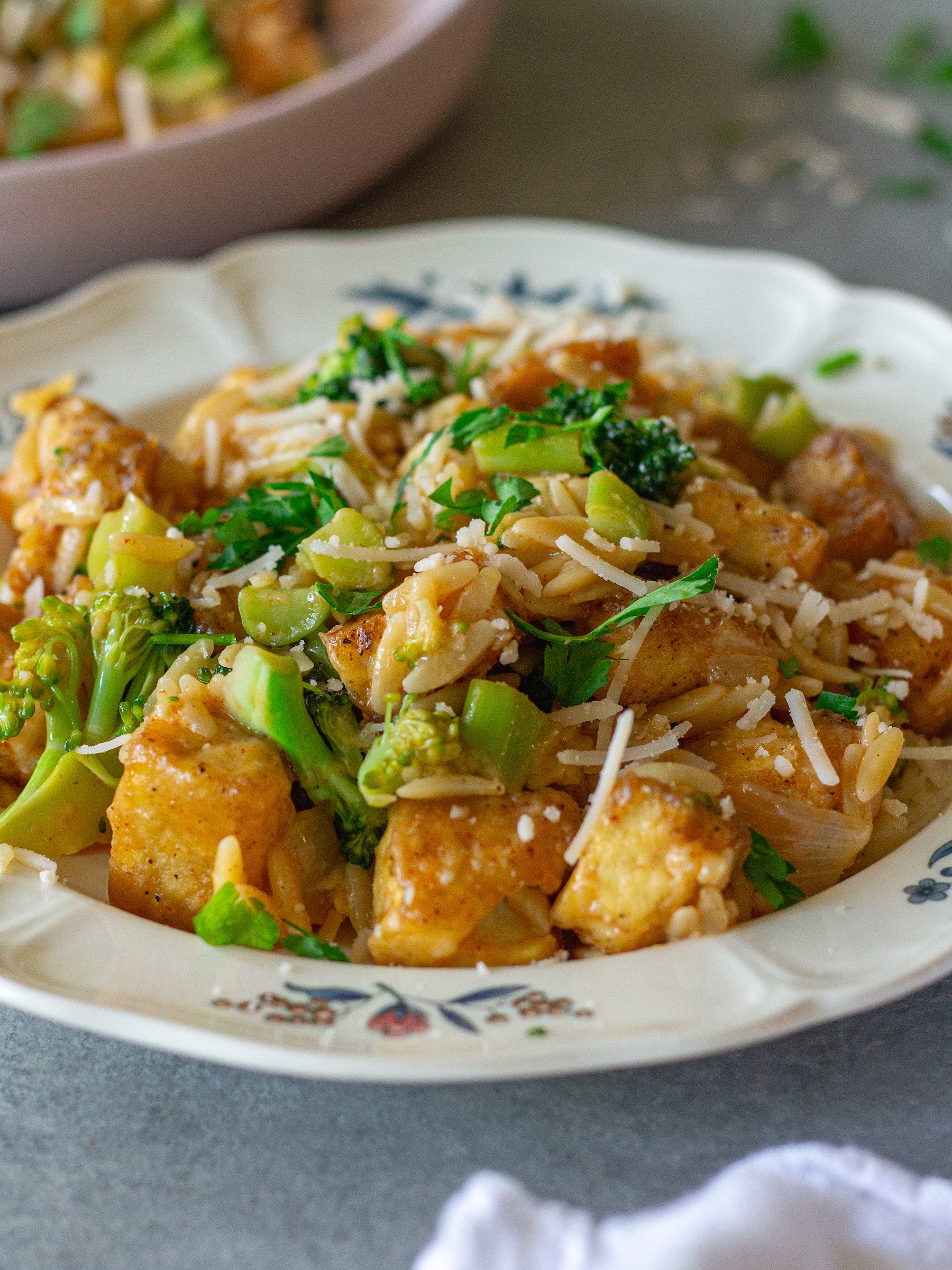 image of creamy One pan Cajun-inspired tofu Alfredo and orzo served on a plate and garnished with vegan parmesan and parsley