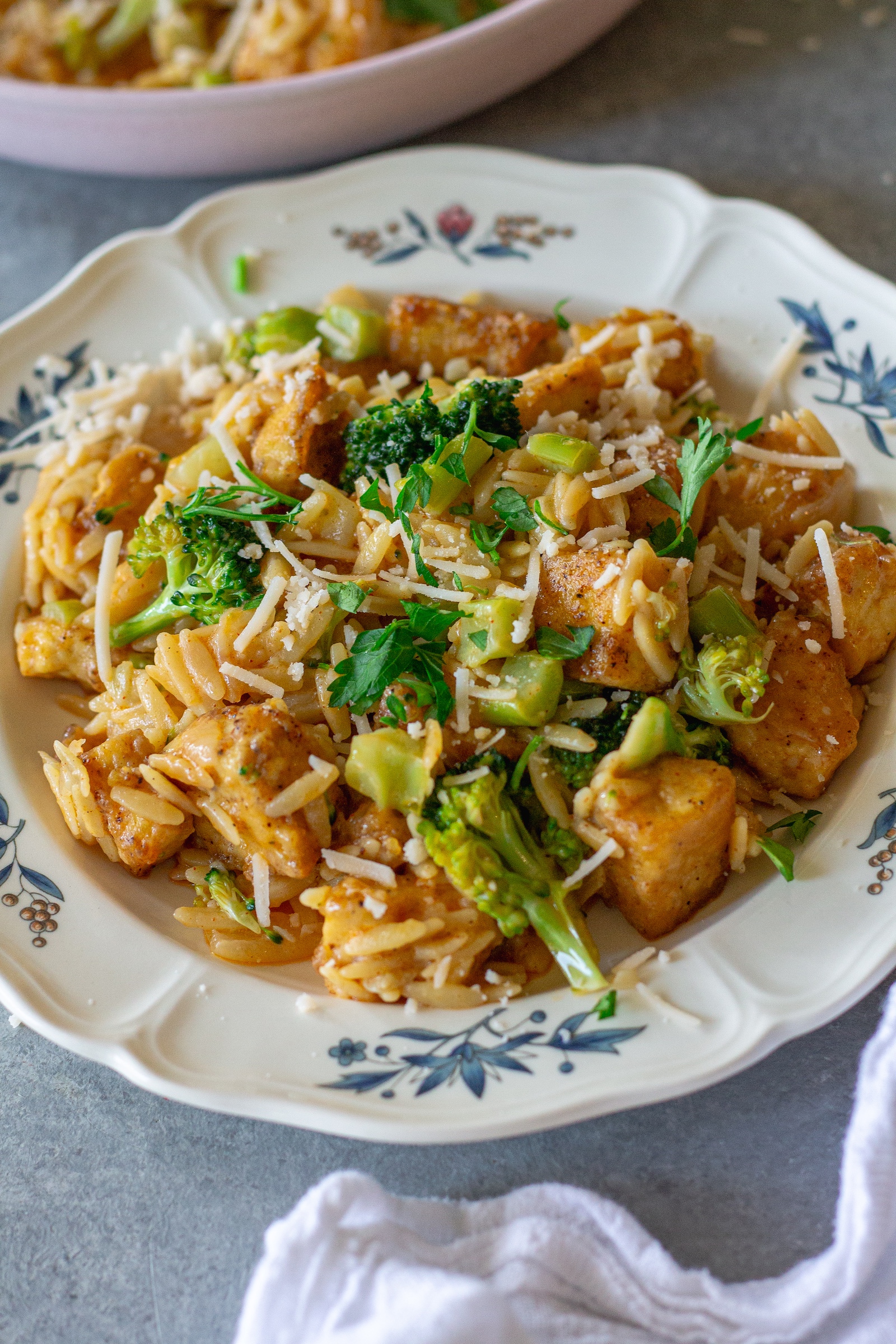 image of creamy One pan Cajun-inspired tofu Alfredo and orzo served on a plate and garnished with vegan parmesan and parsley