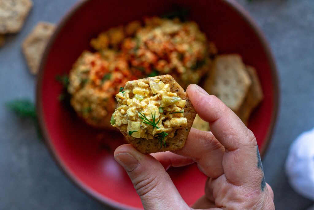 Bowl of Southern‑style vegan ‘chicken’ salad with golden baked tofu, diced tofu, celery, and herbs, topped with smoked paprika.