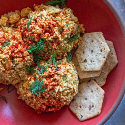 Bowl of Southern‑style vegan ‘chicken’ salad with golden baked tofu, diced tofu, celery, and herbs, topped with smoked paprika.