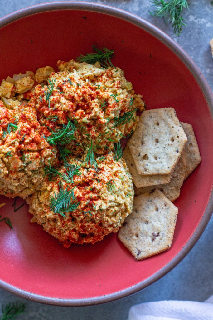 Bowl of Southern‑style vegan ‘chicken’ salad with golden baked tofu, diced tofu, celery, and herbs, topped with smoked paprika.