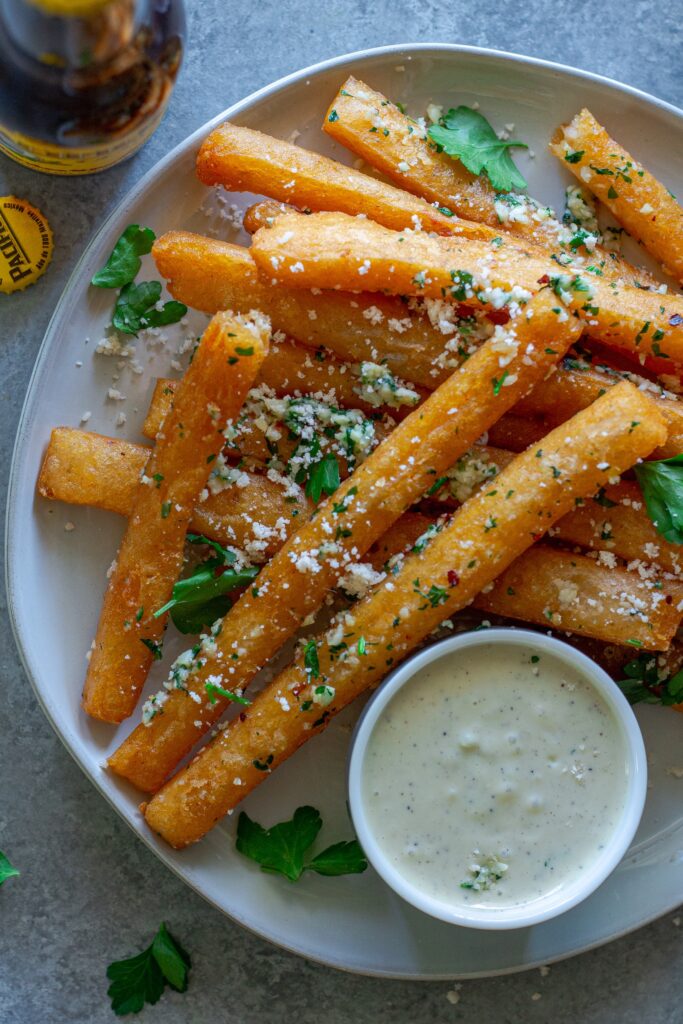 Golden‑brown Japanese‑style long fries tossed in garlic‑parmesan butter, sprinkled with fresh parsley and a side of garlic aioli.