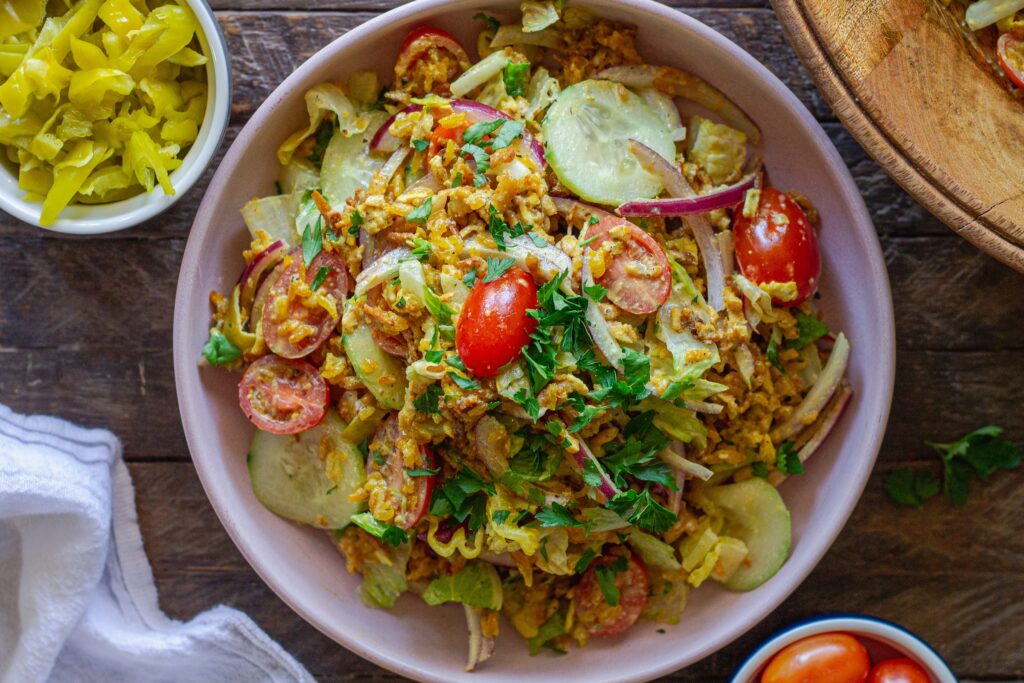 Tofu Shawarma-Inspired Crispy Rice Salad in a large bowl with fresh vegetables and garlicky dressing