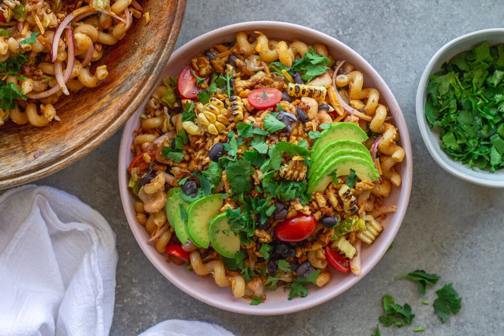 Vegan BBQ chicken pasta salad in a large bowl with crispy tofu, colorful vegetables, and creamy BBQ ranch dressing