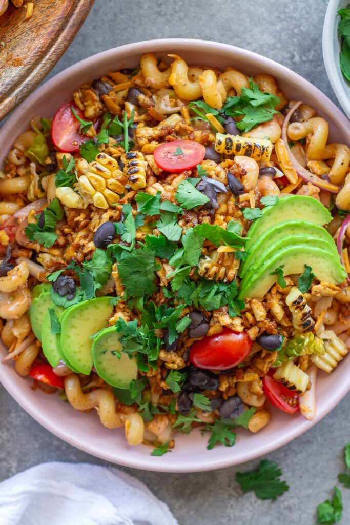 Vegan BBQ chicken pasta salad in a large bowl with crispy tofu, colorful vegetables, and creamy BBQ ranch dressing